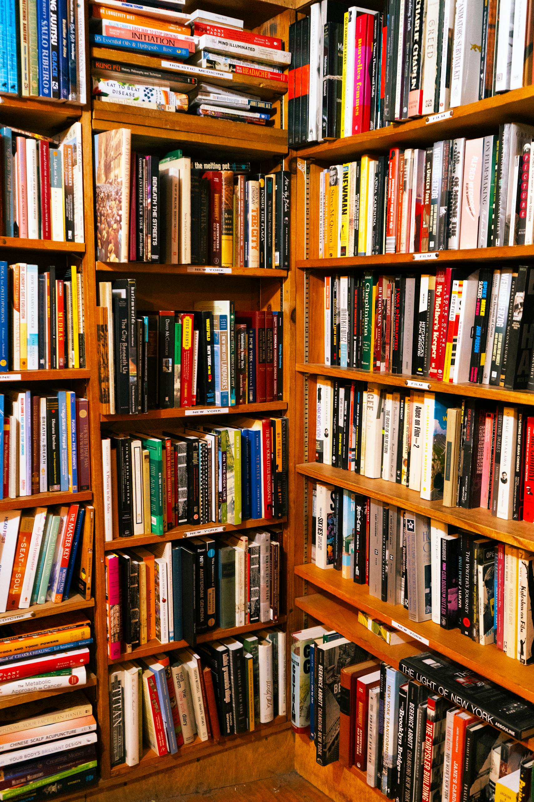 A vibrant library corner packed with diverse books on wooden shelves.